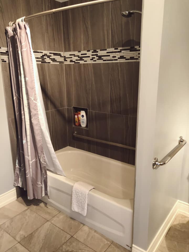 A photo of the bathtub in the accessible suite’s bathroom. Not visible in the photo is a long grab bar at the head of the tub on the wall. There is also a grab bar on the interior wall.