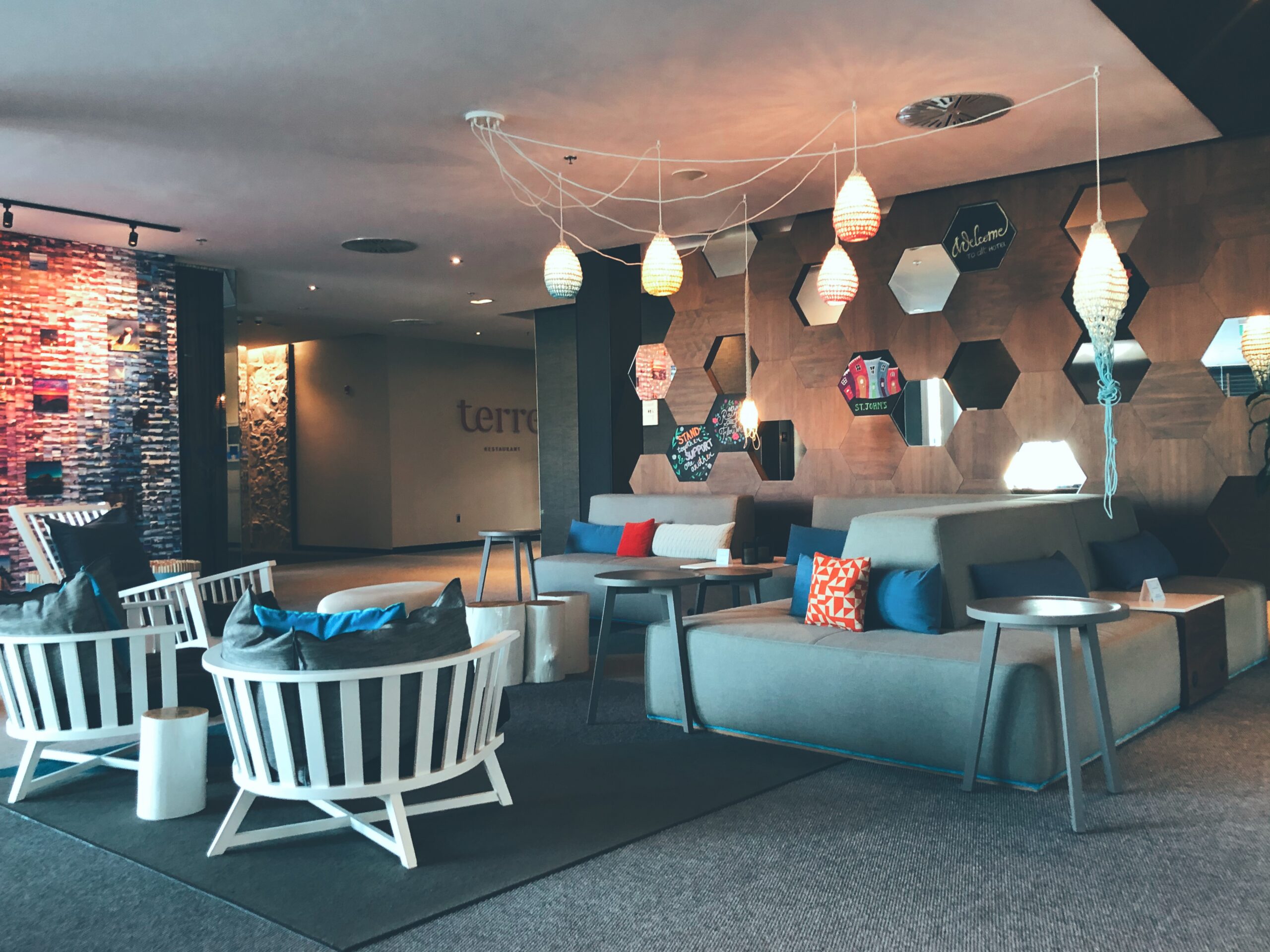 A photo of the Alt Hotel lobby with lots of very fun, modern couches, chairs and ceiling lights.