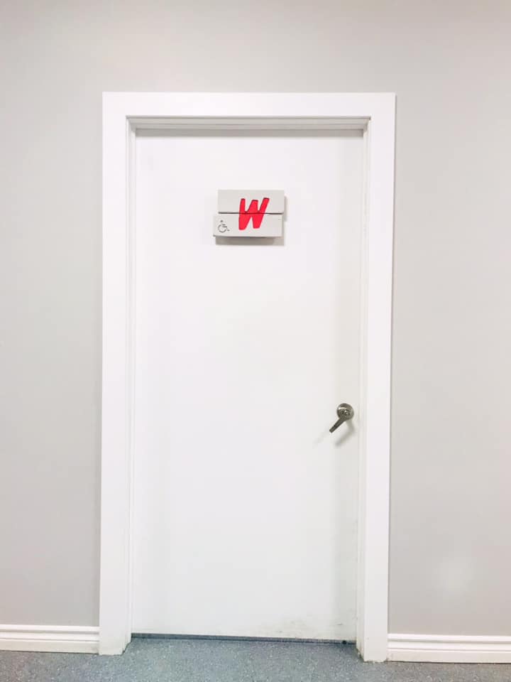 A white washroom door with an accessible sign on it.