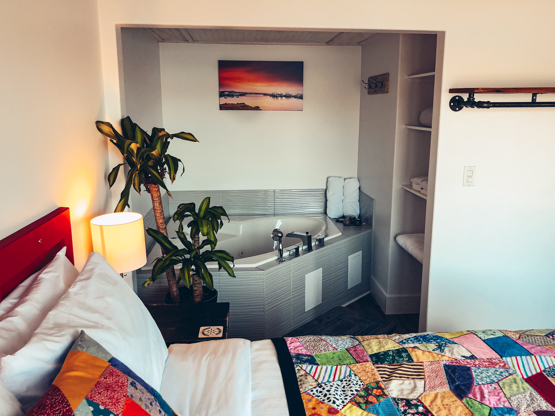 Another angle from the main bedroom of the suite. In this one you can see more of the jacuzzi which is nestled in the corner of the room with shelves of towels nearby.