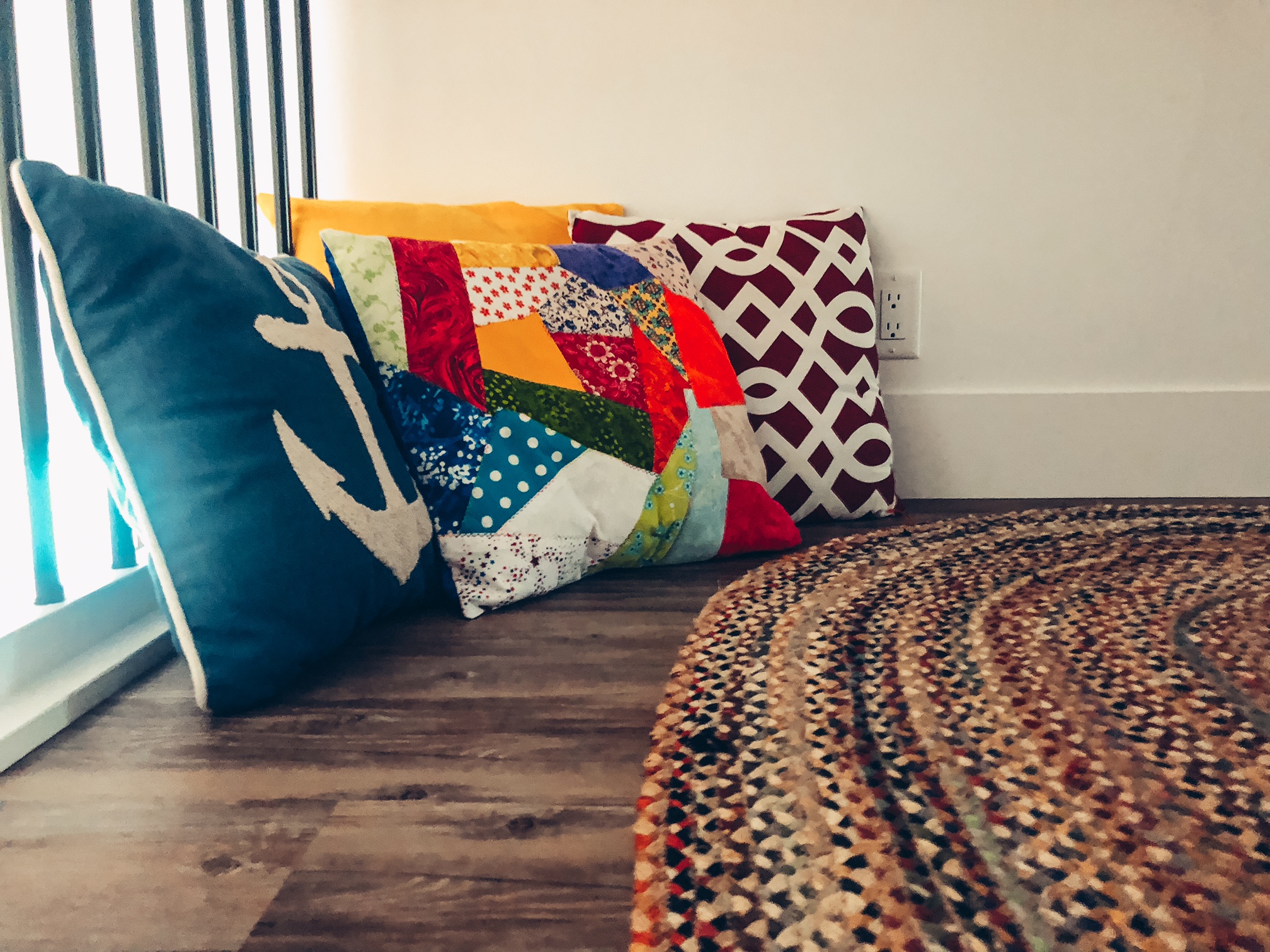 A photo of the corner of the loft room with some colourful cushions placed on the floor.