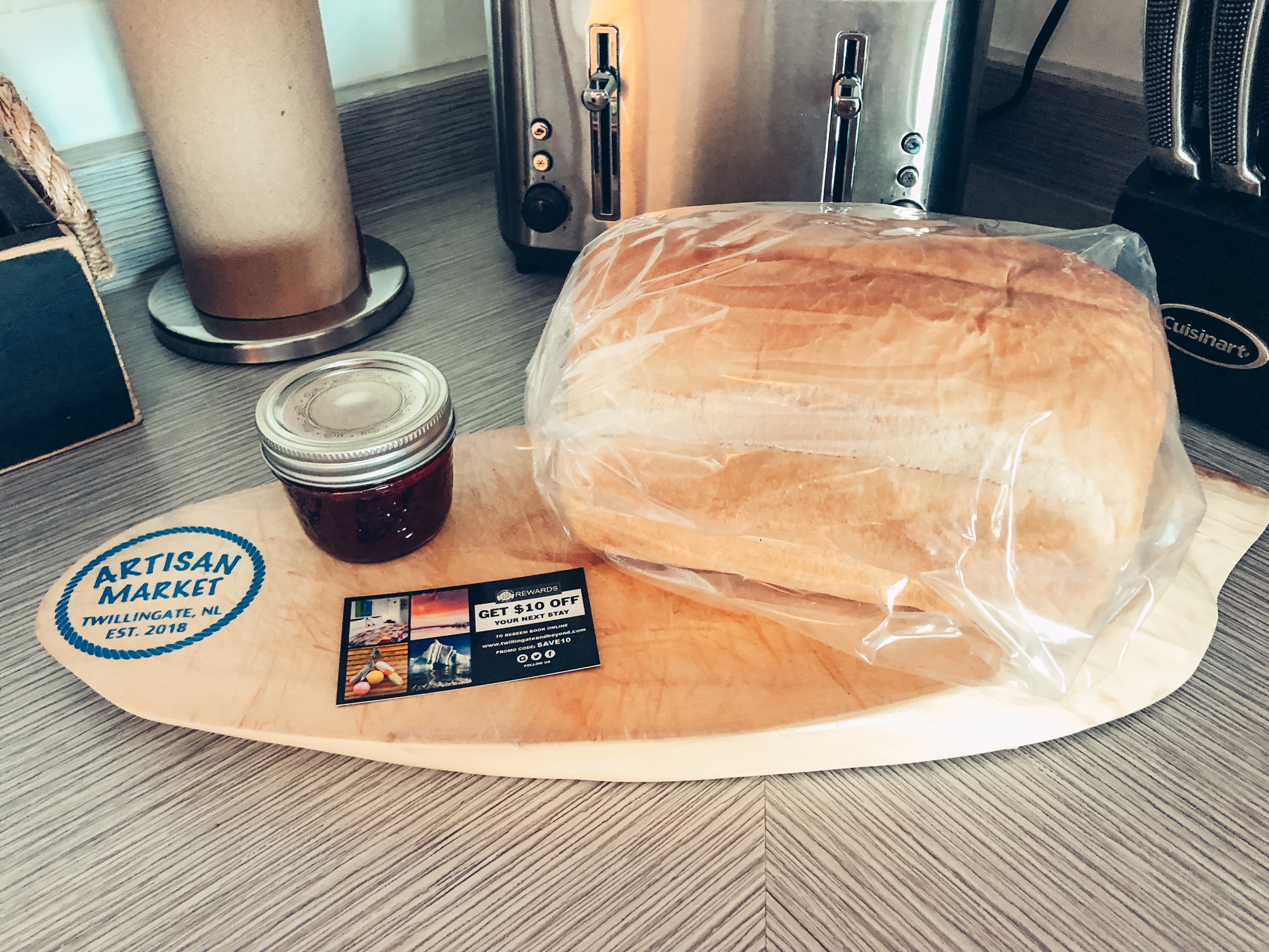 A photo of a fresh loaf of bread and some homemade jam on a cutting board.