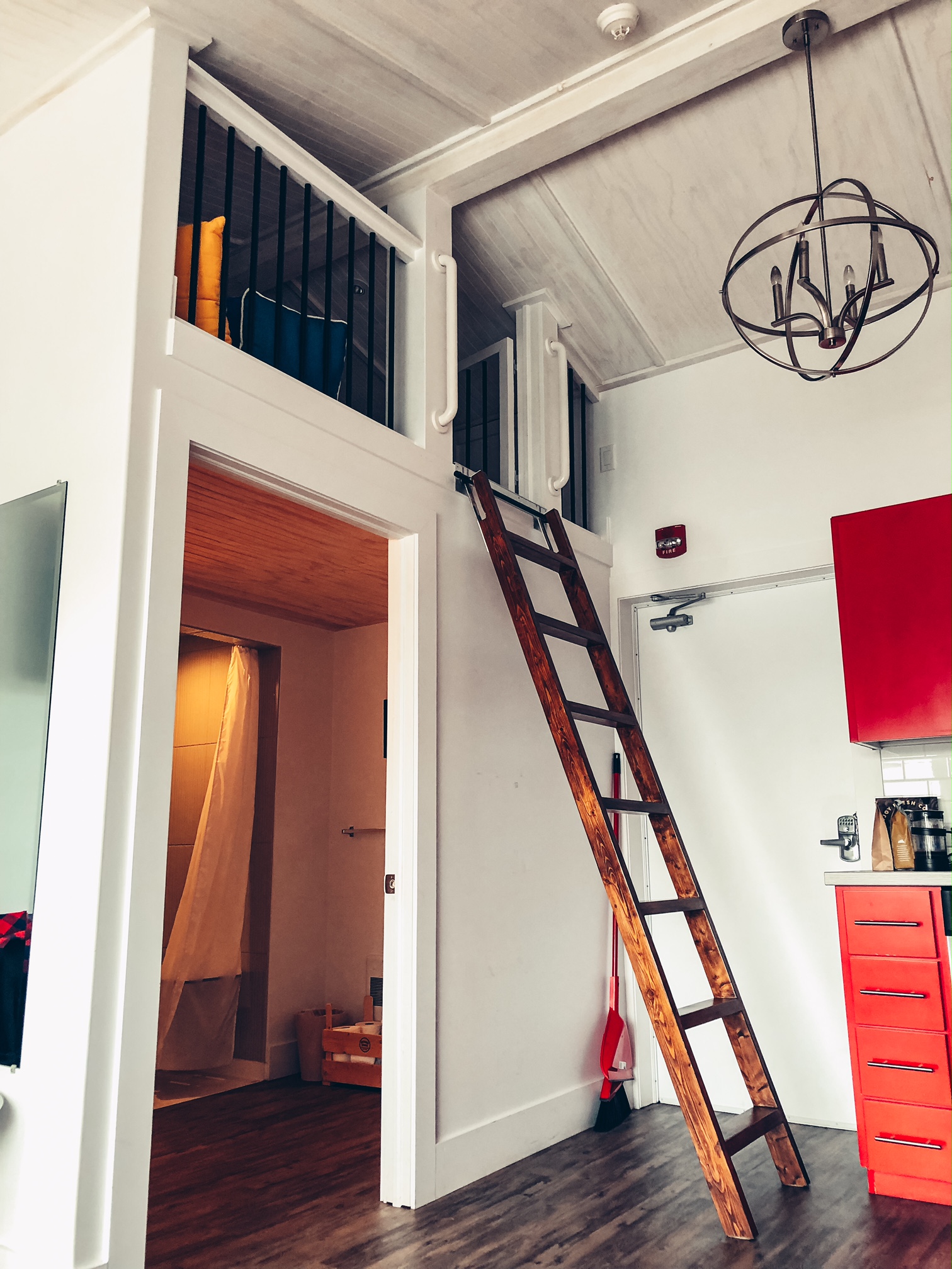 A photo of the wooden ladder in the kitchen area that leads to the loft room.